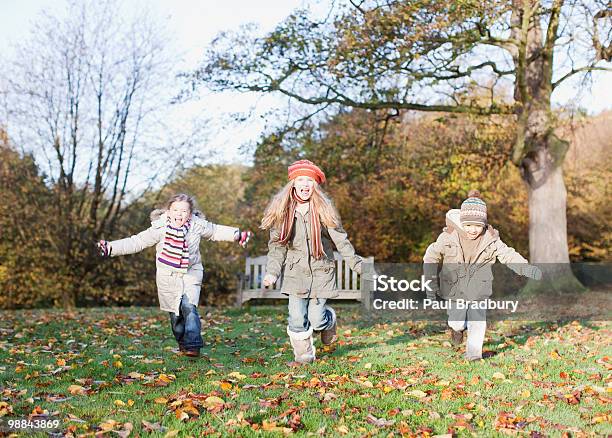 Children Running In Park In Autumn Stock Photo - Download Image Now - Child, Cold Temperature, Playful