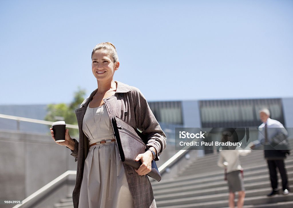 Femme d'affaires avec une marche le long de quelques marches - Photo de Femme d'affaires libre de droits