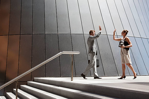 Business people high fiving outdoors  Best Coffee stock pictures, royalty-free photos & images