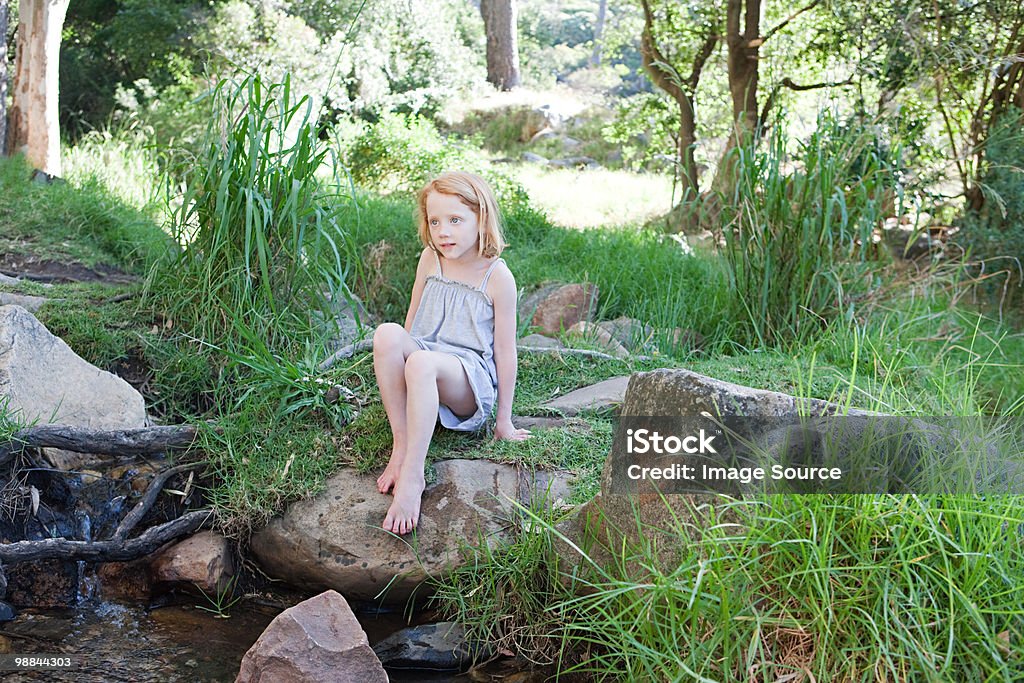 Girl on rocks al río - Foto de stock de Aire libre libre de derechos