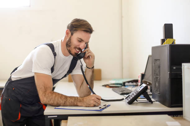 Young woman at front desk talking on the phone.