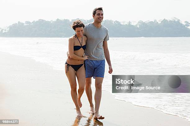 Foto de Couple Walking By The Ocean e mais fotos de stock de 30-34 Anos - 30-34 Anos, Adulto, Adulto de idade mediana