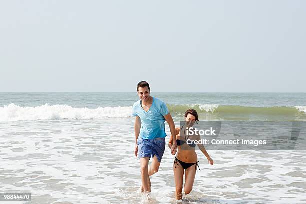 Couple Having Fun In The Sea Stock Photo - Download Image Now - India, Running, 30-34 Years