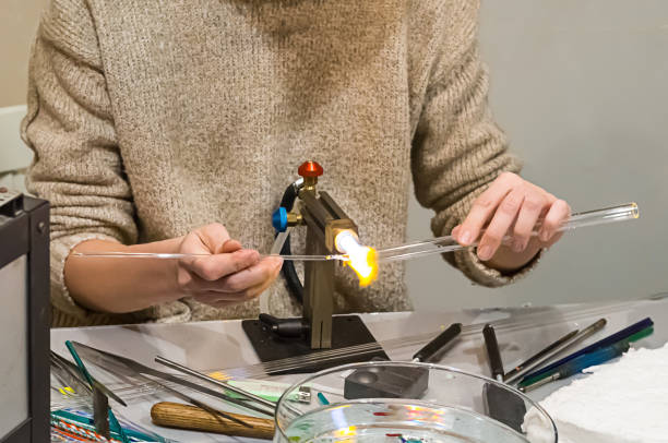 アート ガラスの宝石類製品の製造手ベース管送風機、加熱溶融ガス用バーナの手作りが基本 - glass blower ストックフォトと画像