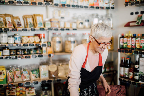 istock Happy woman wearing eyeglasses while working at the store 988478622