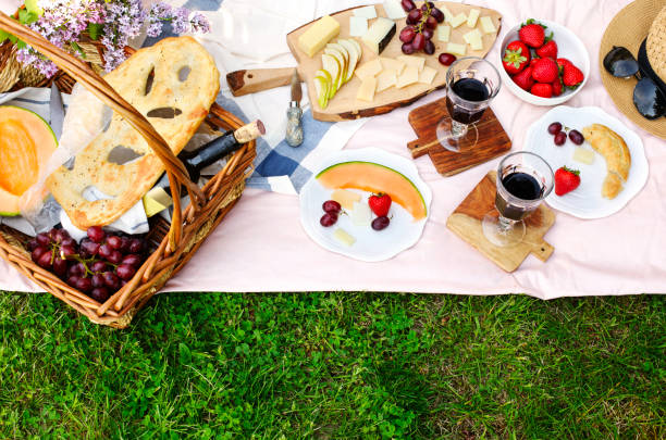 istock Summer picnic with cheese, wine, fruits and bread. 988481280