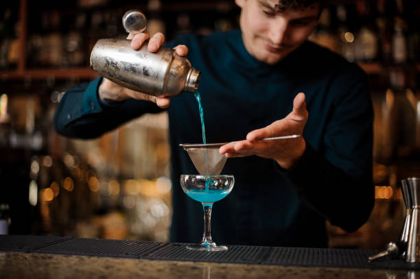 istock barman prepares alcohol cocktail Blue Lagoon 988486058