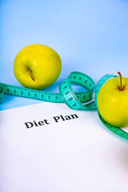istock Apples, diet plan,dumbbells and measuring tape 988486094
