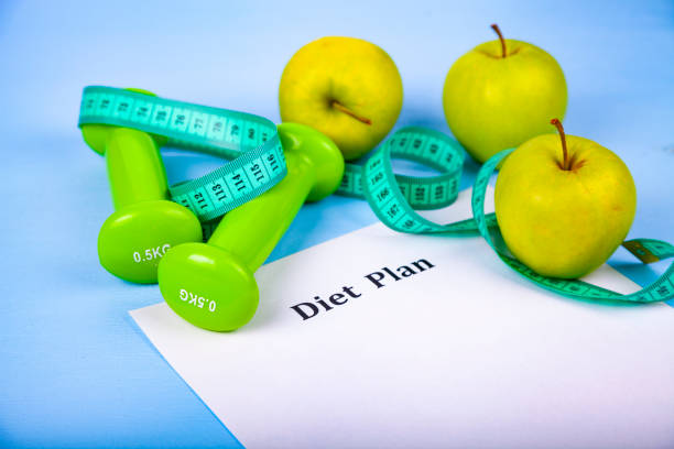 istock Apples, diet plan,dumbbells and measuring tape 988489464