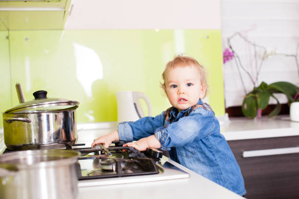 istock Cute boy plays with the gas stove 988496428
