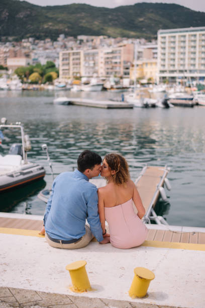 istock Young couple sitting by the marina 988505482