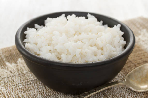 istock boiled rice in black bowl in wooden background 988514070