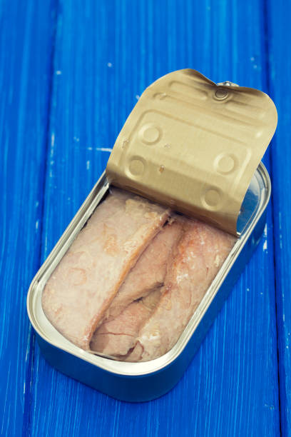 istock fish in oil on iron box on wooden background 988514078