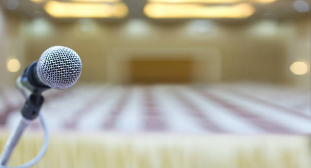 istock Close up. Microphone in conference hall. Business meeting. Microphone Training. Audience at the conference hall. Background blur. 988536090
