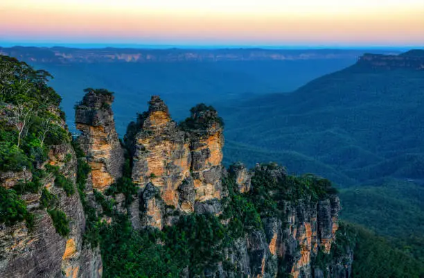 Rugged landscape of Australia's scenic Blue Mountains area at Jamison Valley, with the famous Three Sister's rock formation landmark in the foreground.