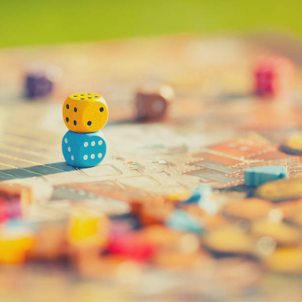 Close up: dices at the table with Board game. Closeup: dices at the table with Board game. Gameplay moments. Random game concept, toned photo. board game stock pictures, royalty-free photos & images