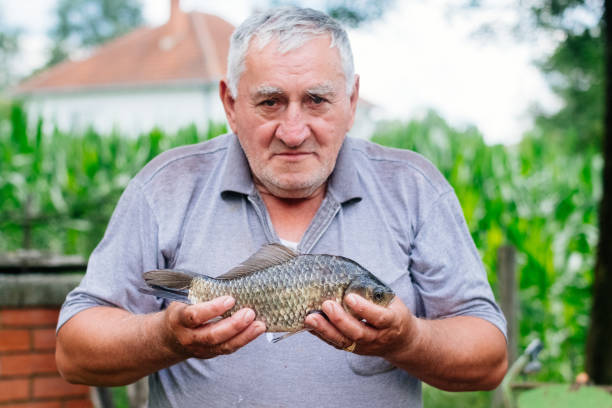 istock Senior man portrait while fishing at a lake 988546210