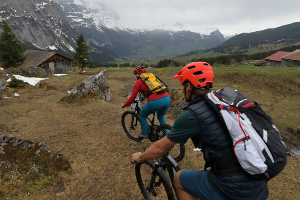 ciclistas de montanha descem a trilha em direção a cabana acima de grindelwald - 24467 - fotografias e filmes do acervo