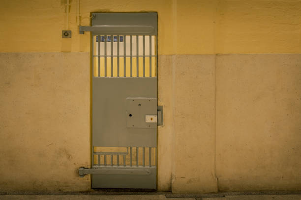 porta de cadeia vintage ferro na prisão do edifício com espaço de cópia em tom cinematográfico - old prison punishment dirty - fotografias e filmes do acervo