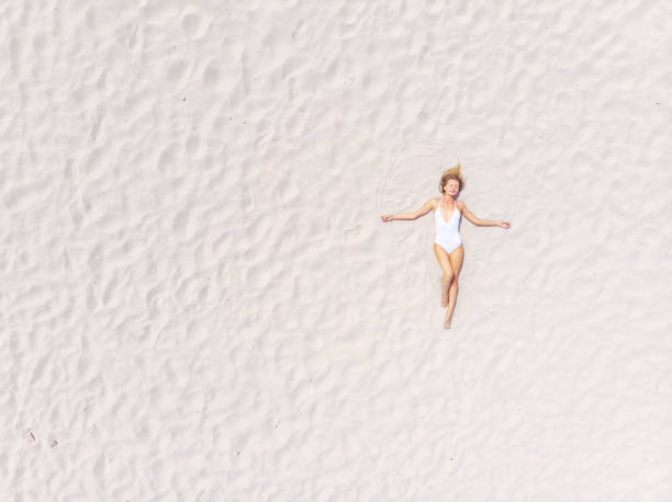 istock Beautiful Woman Lying on Sand at the Beach 988594328