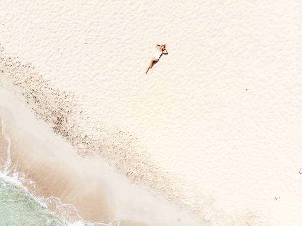 istock Beautiful Woman Lying on Sand at the Beach 988594466