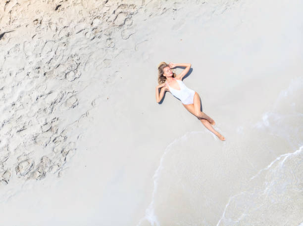 istock Beautiful Woman Lying on Sand at the Beach 988594708