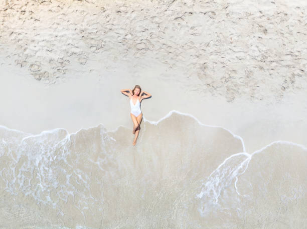 istock Beautiful Woman Lying on Sand at the Beach 988594972