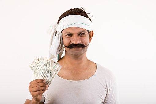 Portrait of farmer holding fanned Indian Rupee notes