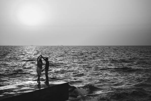 istock Young couple dancing at the pier at the beach summer time 988601272