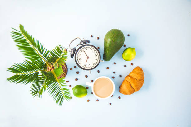 morning breakfast ,coffee in a white cup croissant avocado lime awakening with an alarm clock cheerful, healthy breakfast fresh copy space top view - wakening imagens e fotografias de stock
