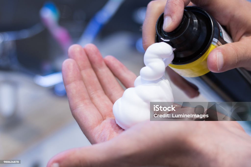 Shaving foam. Close up of man pouring shaving foam on his hand. Shaving Cream Stock Photo