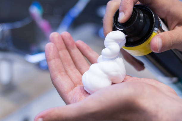 Shaving foam. Close up of man pouring shaving foam on his hand. shaving cream stock pictures, royalty-free photos & images