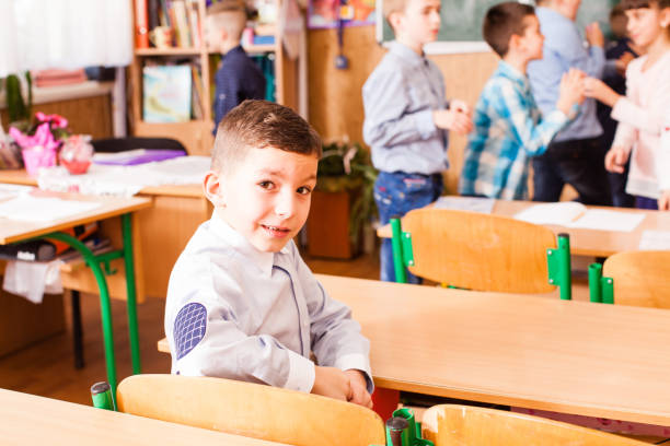 istock cute boy is sitting at the desk in the classrom 988628212