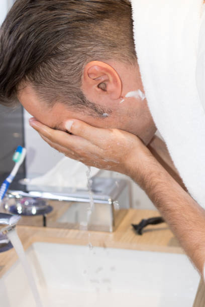 istock Man washing face in the bathroom. 988634388