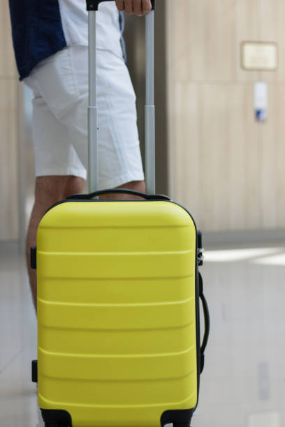 istock Man with suitcase waiting in a lobby. 988640608