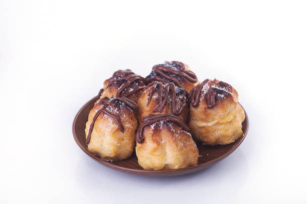 istock Chocolate cream puff isolated on white background. 988644030