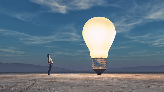 The man looks up towards a big bulb. This is a 3d render illustration.