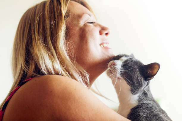 istock Young woman cuddling with her cat indoors 988664690