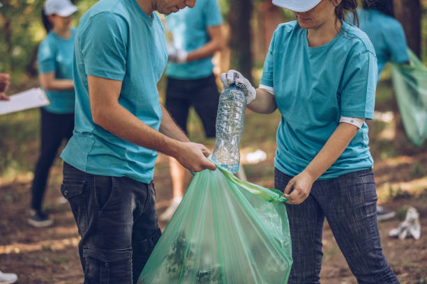 istock Volunteers with garbage bags cleaning park 988669806