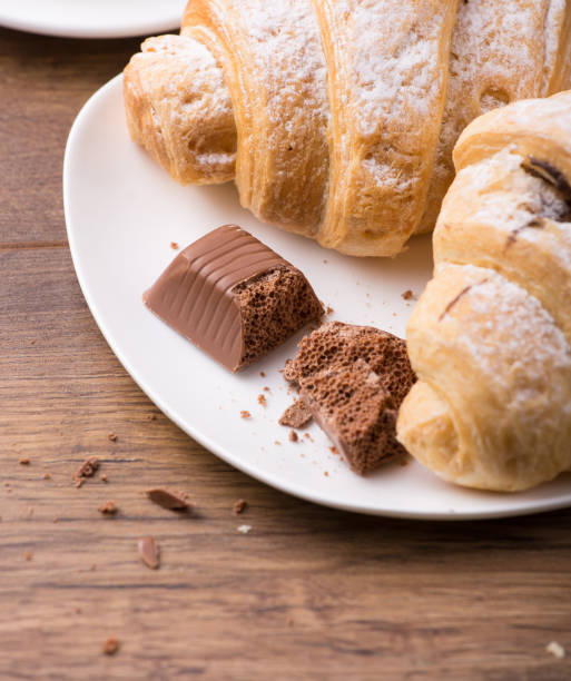 istock Breakfast with coffee, milk and croissants on wooden table 988670976