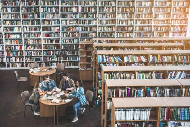istock Positive girls and males learning in library 988674482