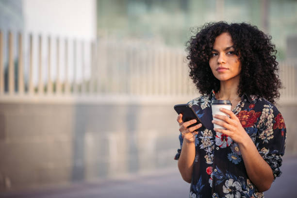 istock Woman using mobile phone outdoors 988676612