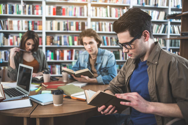 istock Focused comrades looking through information in athenaeum 988676772