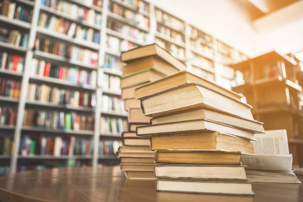 istock Volumes situating on table and shelves 988681814