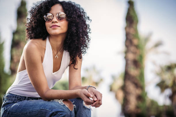 istock Young woman sitting outdoors 988681918