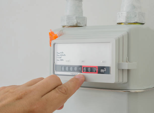 istock Gas meter with a finger pointing at the consumption reading. Counter for distribution domestic gas. Cropped image, selective focus. 988693670