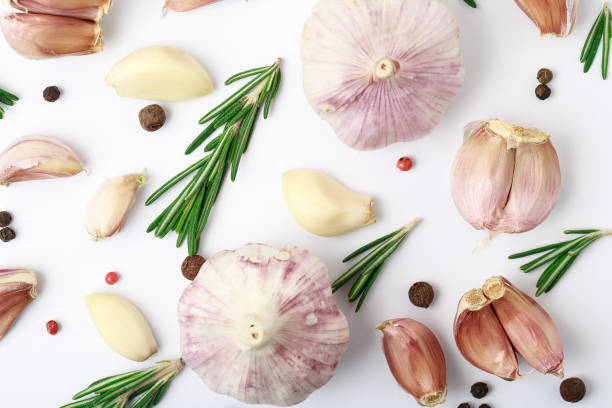istock Garlic with rosemary, black pepper isolated on white background. Isolated garlic 988701964