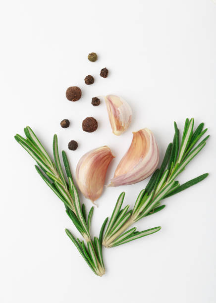 istock Garlic with rosemary, black pepper isolated on white background. Isolated garlic 988702012
