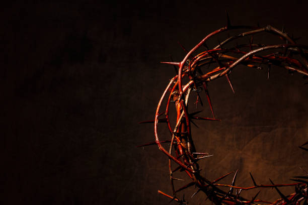 istock Crown of thorns illuminated on a dark background 988703736