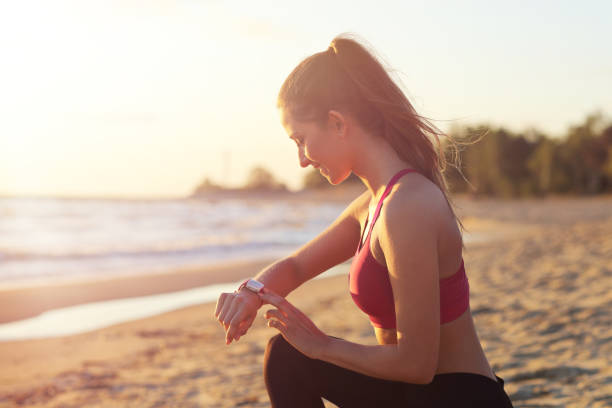istock Woman running alone at beautiful dusk on the beach 988709558